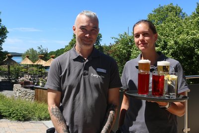 Andy Feller und Virginia Theeg servieren im Biergarten des Bio-Seehotels.