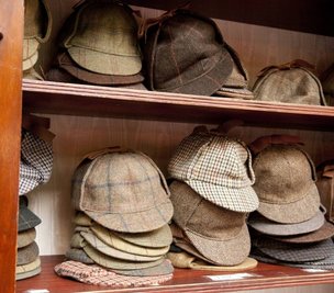 Sogenannte Deerstalker-Mützen im Holmes-Museum in London. In den Geschichten beschreibt Arthur Conan Doyle diese Kopfbedeckung nicht, aber sie tauchte in den Illustrationen auf.