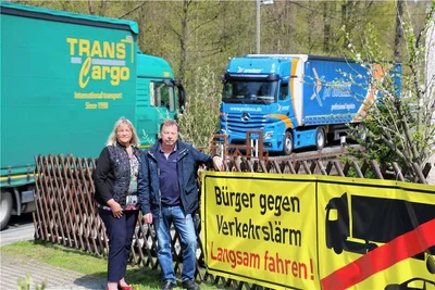 Sabine Schubert und Jürgen Pfoh vor einem der Plakate, auf denen um eine langsamere Fahrweise gebeten wird. 