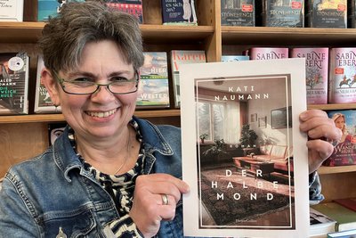 Der Entwurf des Covers ist da. Die Oelsnitzer Buchhändlerin Kathrin Jakob freut sich auf den neuen Roman von Bestsellerautorin Kati Naumann. Er spielt in der Teppichstadt Oelsnitz.