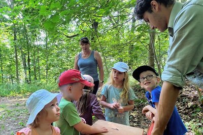 An den Tastboxen zum Erfühlen und Bestimmen ihres Inhalts wie Moos oder Geweihstangen war stets Hochbetrieb. Stationsleiter Dominik Feudel, im Hintergrund Erzieherin Anja Fichtner.