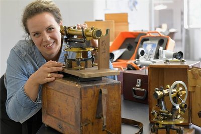 Nadja Lebsuch-Niachos leitet die Montage in der FPM Holding GmbH. Hier prüft sie ein Nivelliergerät von Hildebrand aus der Zeit um 1900. Rechts im Bild ein Theodolit von Lingke von vor 1900. Die historischen Geräte sind in einer Sonderausstellung im Stadt- und Bergbaumuseum zu sehen. 