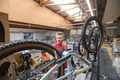 Tim Kohlbach montiert ein Fahrrad der Marke Trek. Der 24-Jährige war 2022 Sachsens bester Lehrling und zeigt auch mit seinem gezwirbelten Schnurrbart die fast 140-jährige Diamant-Tradition.