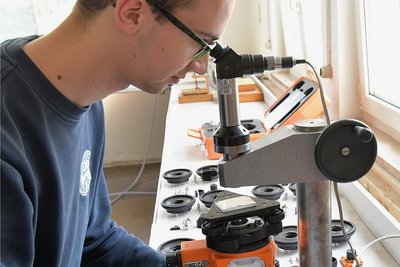 Philipp Jehmlich montiert ein Nadir- und Zenitlot FG L 30, das beim Bau von Hochhäusern, Schornsteinen und Fahrstuhlschächten sowie im Bergwerk eingesetzt wird.