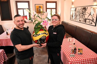 Doreen und Sandro Anzi mit Kunst von Klaus Süß in ihrer Pizzeria in der Spülgasse in Hainichen.