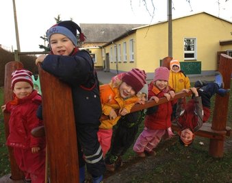 
              <p class="artikelinhalt">Mädchen und Jungen des DRK-Kindergartens "Hüttenzwerge" in Schwarzbach auf ihrem Spielplatz im Freigelände. </p>
            