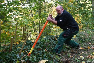 Landschaftsgärtner Lutz Flöter entfernt beim Parkseminar im Wechselburger Schlosspark eine Wurzel.