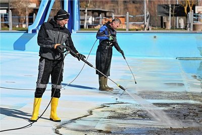 Rettungsschwimmer Tom Hennig (vorn) und Schwimmmeister Jan Kugler reinigen das Becken. 