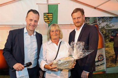 CDU-Landtagskandidat Jörg Schmidt (links) und Sachsens Ministerpräsident Michael Kretschmer (CDU) würdigten das Engagement von Petra Barig im Siedlerverein Plauen-Sorga.
