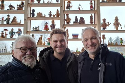 Rolf Höfer sowie Florian und Lutz Kunze (v. l.) vor der Räuchermännelwand auf der Terrasse, die nach Lichtmess aber wieder abgebaut wird. Die hölzernen Senioren im Gastraum indes bleiben in „Räuchermännelsruh 2.0“ stehen.