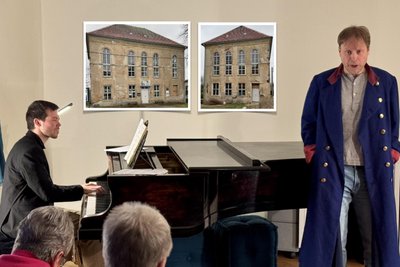 Joaquim Font (Klavier) und Markus Gille führten „Die schöne Müllerin“ auf. Im Hintergrund Fotos vom zu sanierenden Schul- und Bethaus in Bräunsdorf.