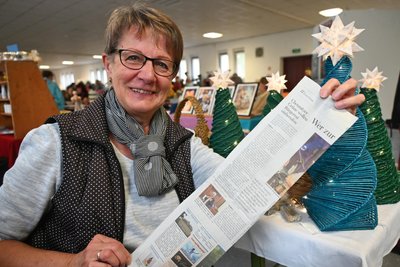 Ibolya Schiefelbein präsentiert Weihnachtsbäume, die aus Zeitungspapier entstehen.