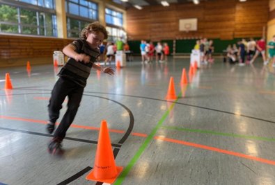 Ein Schüler an der Wendemarke des "Kindersprint"-Laufparcours. Zurück zum Start und Ziel geht es im Slalom. 