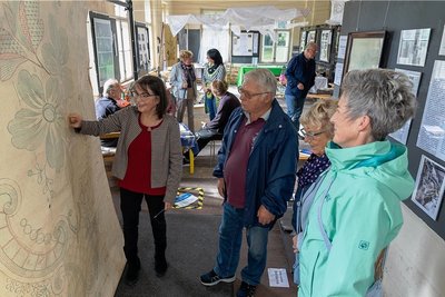 Petra Gronem-Schlosser (links) führt Besucher durch die Ausstellung, die Pfingsten in der Alten Stickerei Grünbach gezeigt wurde. 