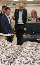 Abgeordneter Philipp Hartewig, Geschäftsführer Justus Rau und IHK-Chefin Cindy Krause (vorn v.l.n.r.) an einer Digitaldruckmaschine der Firma Innotex.