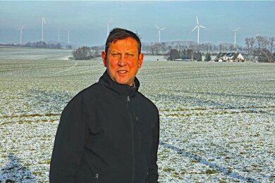 Ortsvorsteher Jan Schleicher vor den bereits bestehenden Windrädern an der thüringischen Landesgrenze. 