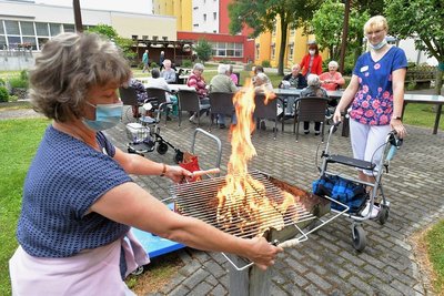 Beate Grohmann vom Betreuungsdienst und Pflegerin Nadin Uhlig (v.v.l.) sind Feuer und Flamme für ihren Beruf und zeigen das auch bei der Gestaltung eines Grillabends für die Bewohner des Seniorenheims Johanna Rau in Freiberg. Im Rahmen der Woche der offenen Unternehmen haben sich für Samstag fünf Interessenten hier angemeldet.