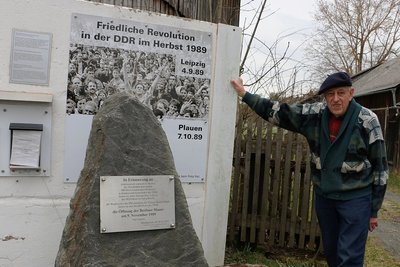 Gerhard Morgner zeigt die neugestaltete Bildtafel am Gedenkstein in Mödlareuth. 
