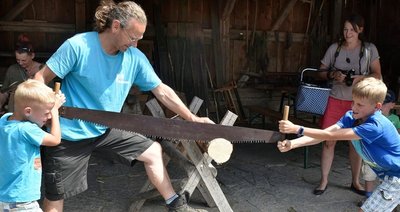 Museumsmitarbeiter Rico Kuharski gibt Hilfestellung beim Abtrennen einer Baumscheibe mit der Schrotsäge.