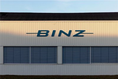 Das Logo des Sonderfahrzeughersteller Binz auf einer Werkhalle wird von der Sonne angeleuchtet. Das Thüringer Unternehmen übernimmt das MAN-Werk im sächsischen Plauen. Der Betriebsübergang soll zum 1. April 2021 erfolgen. +++ dpa-Bildfunk +++