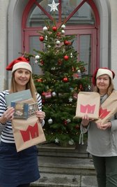 Anna Engel (l.) und Winnie Richter von der Öffentlichkeitsarbeit des Theaters mit der neuen Weihnachtswundertüte. 
