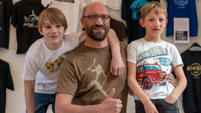 Für die "Freie Presse" sind Freiwillige aus dem Schlossteam in T-Shirts geschlüpft. Ronny Dietze (47) ist Hausmeister. Dass er dieses Shirt trägt, ist eher Zufall. Es lag ganz oben im Schrank. Gleichzeitig zeigt es in einer alten Darstellung ein Hobby des Rochsburgers: das Bogenschießen. Sein Sohn Till (13, l.) trägt ein Shirt, das ihm seine Tante aus Ägypten mitgebracht hat. Sohn Toni (8) verdeutlicht mit seiner Auswahl: Er mag das Thema Feuerwehr. 