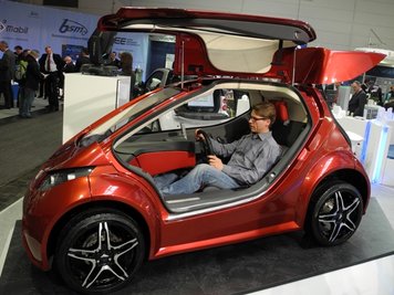 Der TU-Mitarbeiter Robert Stelzer testet den Bedienkomfort des Elektroautos Colibri. Es hat drei nach oben öffnende Flügeltüren.