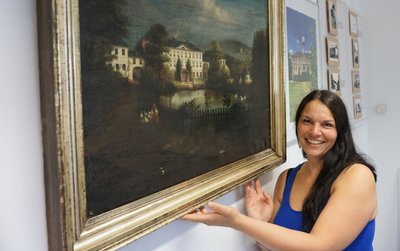 Annegret Klemm, neue Leiterin der Kultur- und Touristinformation Oelsnitz, zeigt ein Gemälde der schlossartigen Anlage von 1860.