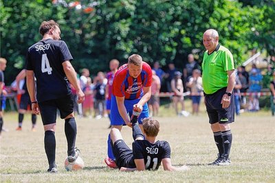 Schiedsrichter Angelo Stringile (r.) hatte die Rekord-Partie im Griff. Der Meeraner Tim Trompke half in dieser Szene dem krampfgeplagten Fabien-Uwe Zipfel von der SpG Schönberg/Oberwiera. 