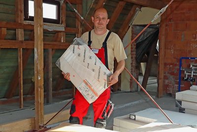 André Helbig sortiert auf dem Dachboden die neuen Heizkörper.