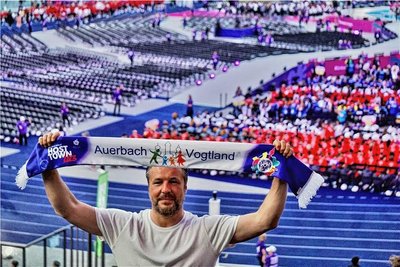 Auerbachs Bauamtsleiter Patrick Zschiesche jubelnd im Stadion mit dem Fanschal.