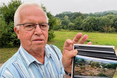 Peter Richter mit seinen Fotos vom Hochwasser. Auf der Fläche hinter ihm befand sich die Kleingartenanlage "Sonneninsel".