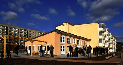 
              <p class="artikelinhalt">Was zuvor noch graue "Platte" war, ist nach Teilrückbau und Umbau, Sanierung, Modernisierung und Anbau sowieschmucker Farbgebung zum sehenswerten Genossenschaftszentrum Am Fichtbusch geworden.</p>
            