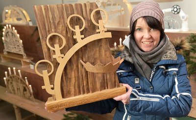 Stollbergs Marktmeisterin Bärbel Raatz zeigt den Pokal für den Schwibbogen-König. 