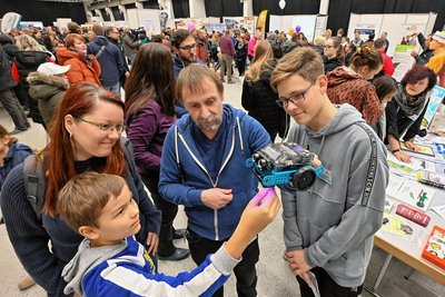 Conny Glowa mit ihrem Sohn Emil am Stand der Oberschule "Am Flughafen" im Gespräch mit Lehrer Dieter Kunz und Schüler Nico Herrmann 