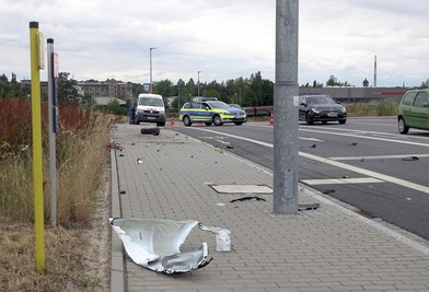 Fahrzeugteile verteilten sich auf Straße und Fußweg.