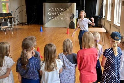 Luisa Heilmann, vom Team der Kohlewelt (vorn) mit Kindern am Saurier-Parcours.