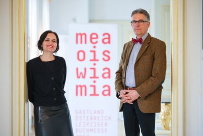 Katja Gasser, künstlerische Leiterin des Gastlandauftritts Österreich, und Oliver Zille, Direktor Leipziger Buchmesse, stehen bei der Programmpressekonferenz im Gohliser Schlösschen unter anderem das Motto des Gastlandes vor: "Mea ois wie mia" bedeutet "Mehr als nur wir" und soll das bekannte "Mia san mia" ("Wir sind wir") konterkarieren.