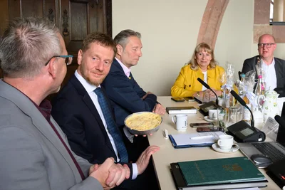 Landrat Sven Krüger (l.), überreicht Regierungschef Michael Kretschmer (2. v. l.) zur auswärtigen Kabinettssitzung im Schloss Rochlitz im Beisein von OB Frank Dehne (Mitte), Vizeregierungschefin Petra Köpping und SPD-Landtagsfraktionschef Henning Homann eine typische Freiberger Eierschecke.
