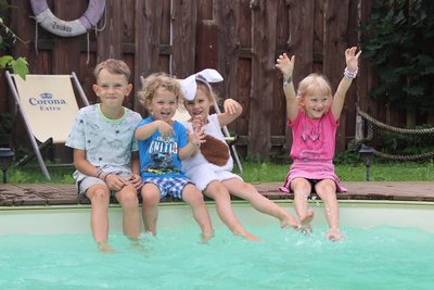 Thorin (Zweiter von links) und Maivi (Zweite von rechts) verabschieden sich von ihren Freunden Adrian (links) und Eliza beim Spielen am Pool.