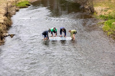 Die Aktivisten ließen eines ihrer Plakate schwimmen. Es wurde später wieder herausgefischt.