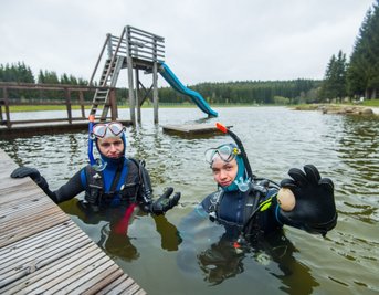 Dominik Schwarz (links) und Jannik Scholz vom Outdoorteam Westerzgebirge haben im Naturbad Johanngeorgenstadt nach Müll getaucht. Besonders erstaunt waren sie über das Ei, das Jannik in der Hand hält. 