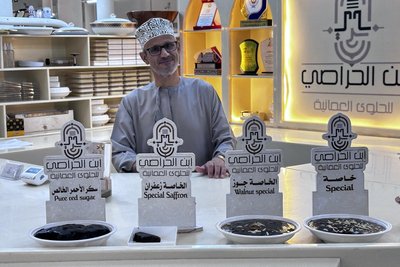 Händler im Souq mit omanischen Süßspeisen.