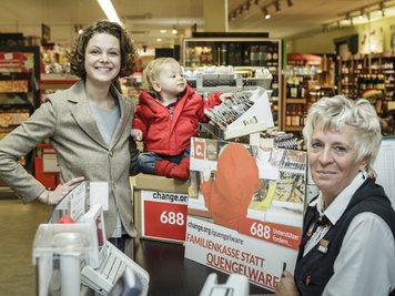 Die Berlinern Caroline Rosales (l) steht mit Söhnchen Maxime neben einer Verkäuferin an der Kasse eines Supermarktes in ihrem Kiez im Berliner Bezirk Prenzlauer Berg. Die jungen Mutter startete erfolgreich eine Internet-Petition gegen «Quengelkassen». Die Supermarktfiliale in ihrer Nachbarschaft wird ab Januar «Familienkassen» einrichten: ohne Süßigkeiten als Lockmittel für die Kleinen in der Warteschlange.