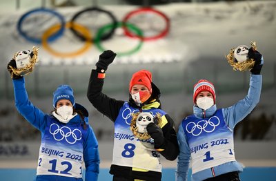 Denise Herrmann vom WSC Erzgebirge Oberwiesenthal jubelt bei der Flower Ceremony nach dem Gewinn der Goldmedaille vor Anais Chevalier-Bouchet (l) aus Frankreich und Marte Olsbu Roeiseland aus Norwegen.