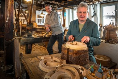 Hans-Günter Flath und Dirk Weber (l.) drehen im Seiffener Freilichtmuseum Reifen und spalten danach Figuren ab.