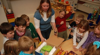 Gespannt packten am Montag die Hortkinder und Leiterin Susanne Teubert das Einzugsgeschenk von Bürgermeister Enrico Bräunig aus.