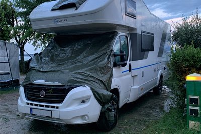 Mit Planen wurden die zerstörten Scheiben dieses Wohnwagens nach dem Hagelunwetter abgedeckt. Er gehört einem Mitcamper von Burmeister.