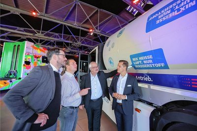 Fachdiskussion auf dem Logistikforum im Chemnitzer Eventzentrum "Kraftverkehr": Frank Rößler von Movia-Tec (von links), Gert Schlegel von Hzwo, Markus Bauer von Schloz Wöllenstein und Julian Neuhaus von Faun Umwelttechnik an einem Lastkraftwagen, der mit Wasserstoff betrieben wird.