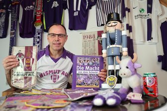 80 Jahre Erzgebirge Aue: Erzgebirge im Herzen – Wismut im Blut. Wenn die Macht aus dem Schacht mit dir ist - Lila-Weiß ein Leben lang: „Freie Presse“-Reporter Kjell Riedel mit einigen Veilchen-Souvenirs, die sich in rund 50 Jahren angesammelt haben. Der Nussknacker ist ein Unikat aus Papas Werkstatt. Das Buch entstand vor 20 Jahren.